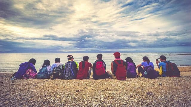 Group of people seating in front a beautiful landscape