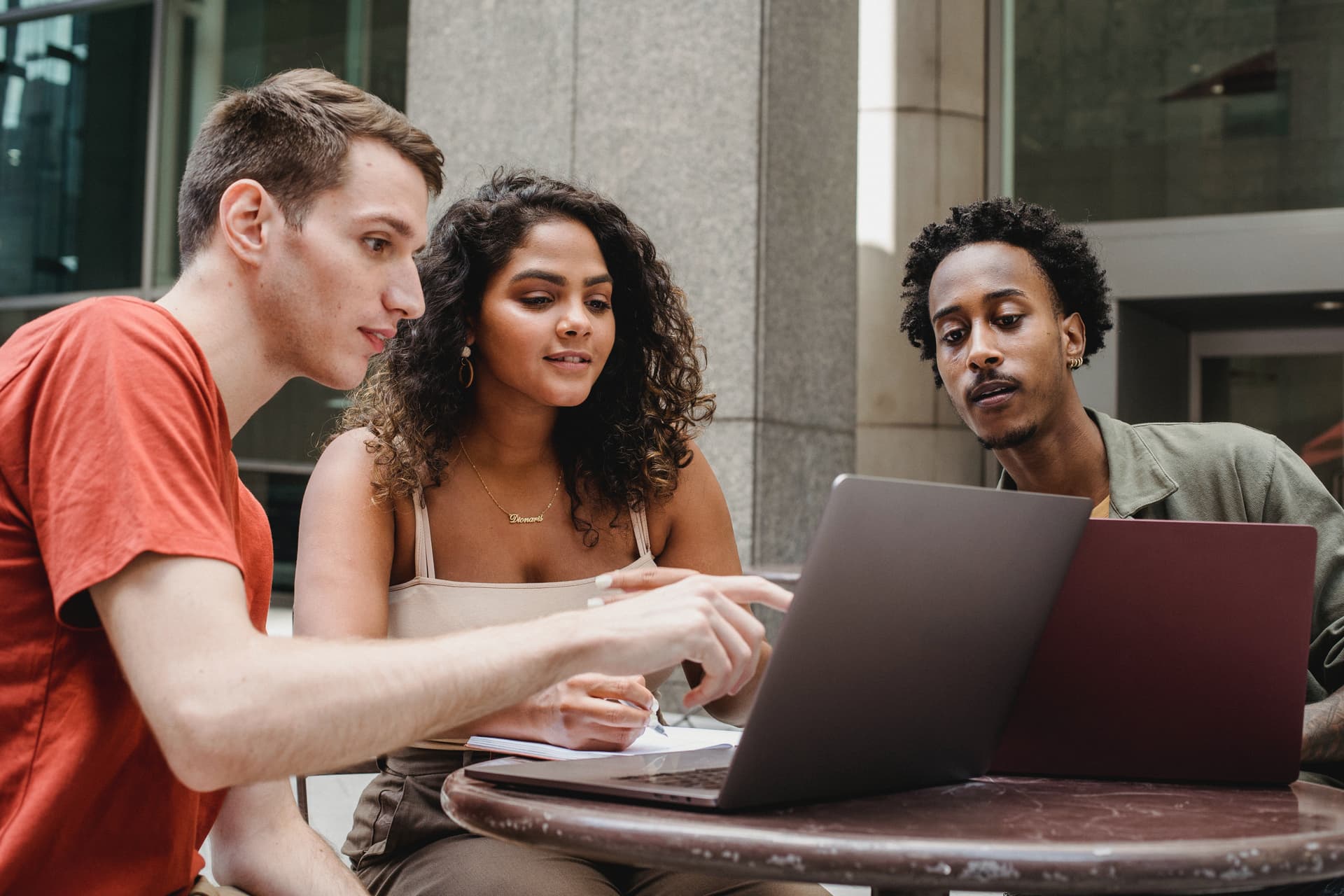 Trois jeunes qui discutent devant un ordinateur
