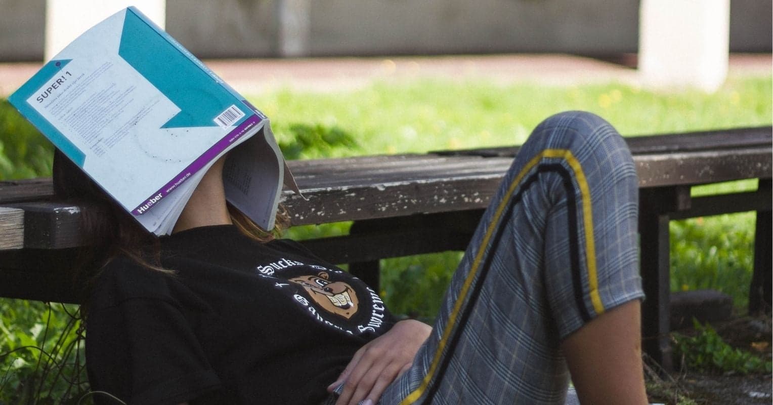 A laid down person with a book on their face