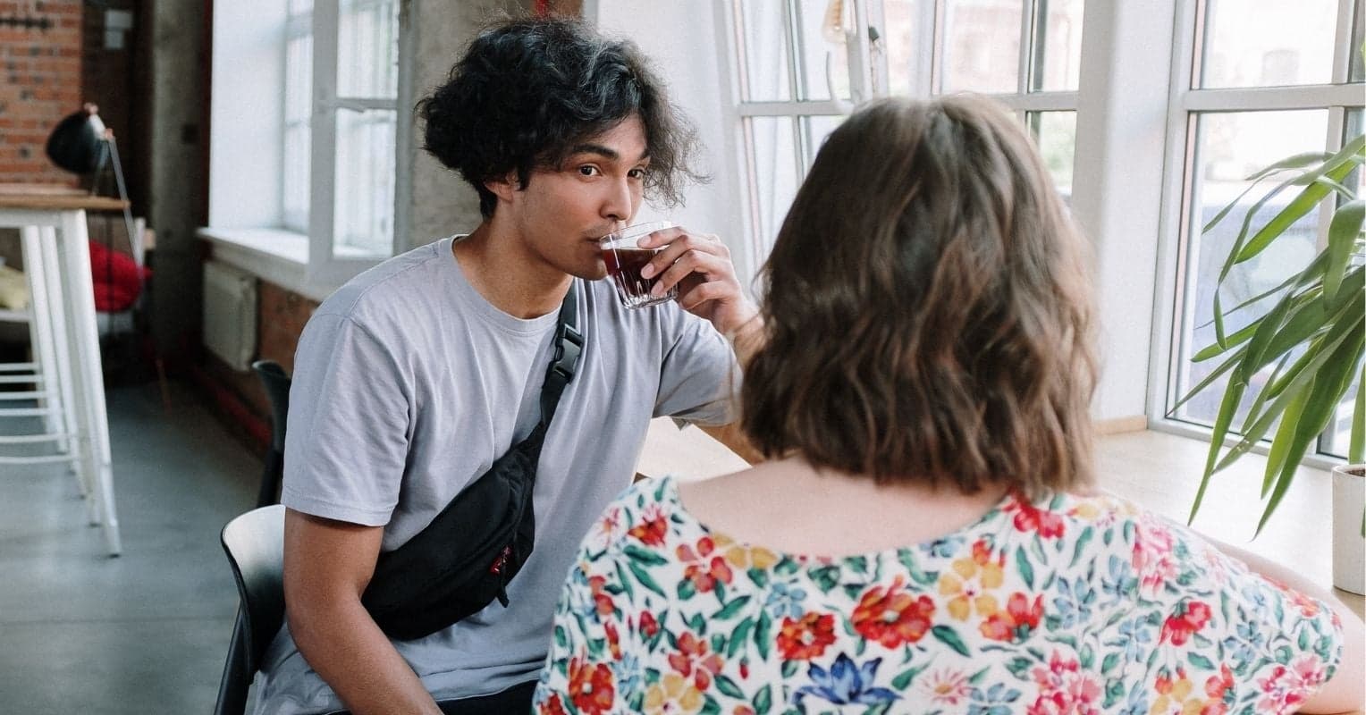 Un homme et une femme (de dos) qui prennent une pause café au travail