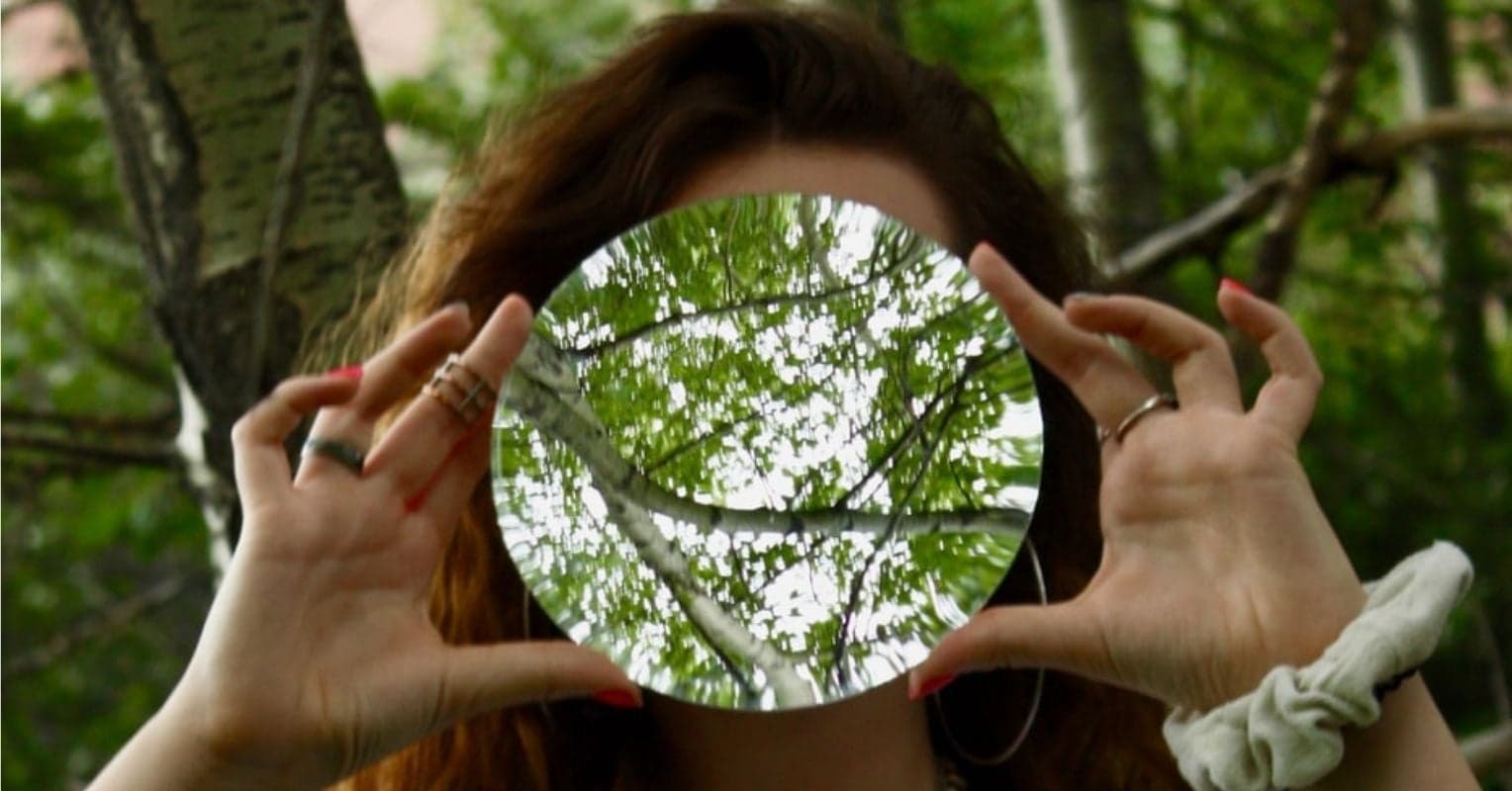 une femme avec un miroir devant le visage