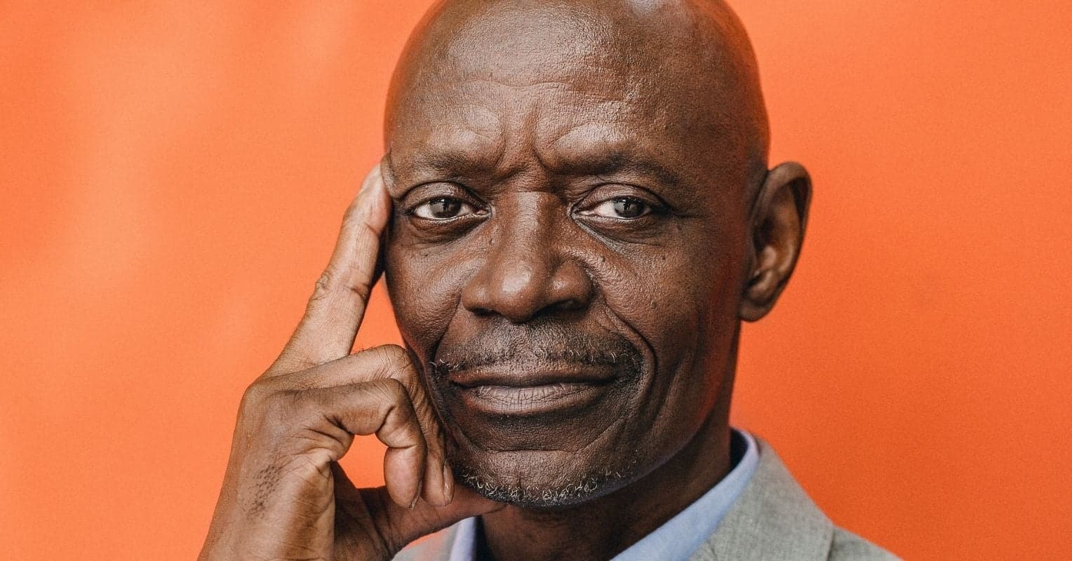 The face of a man in front of an orange background
