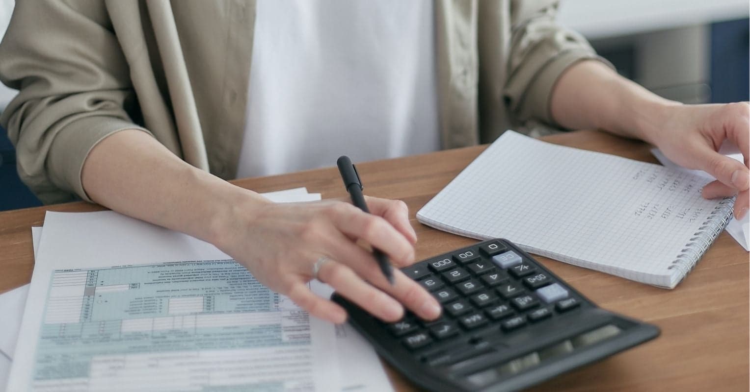 Gros plan sur la main d'une femme qui utilise une calculatrice