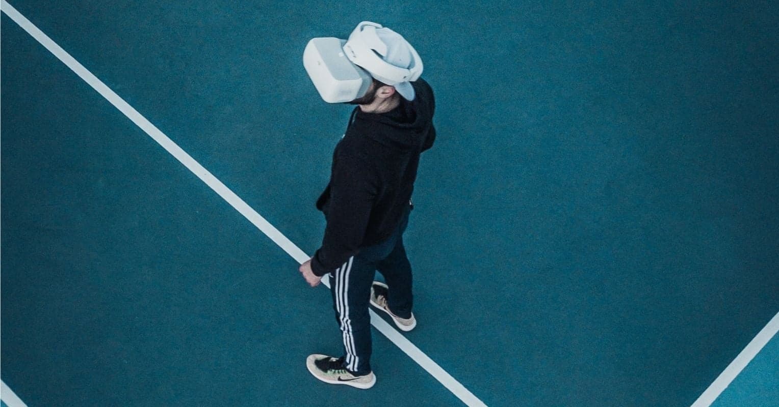 A man on a tennis court with a VR headset
