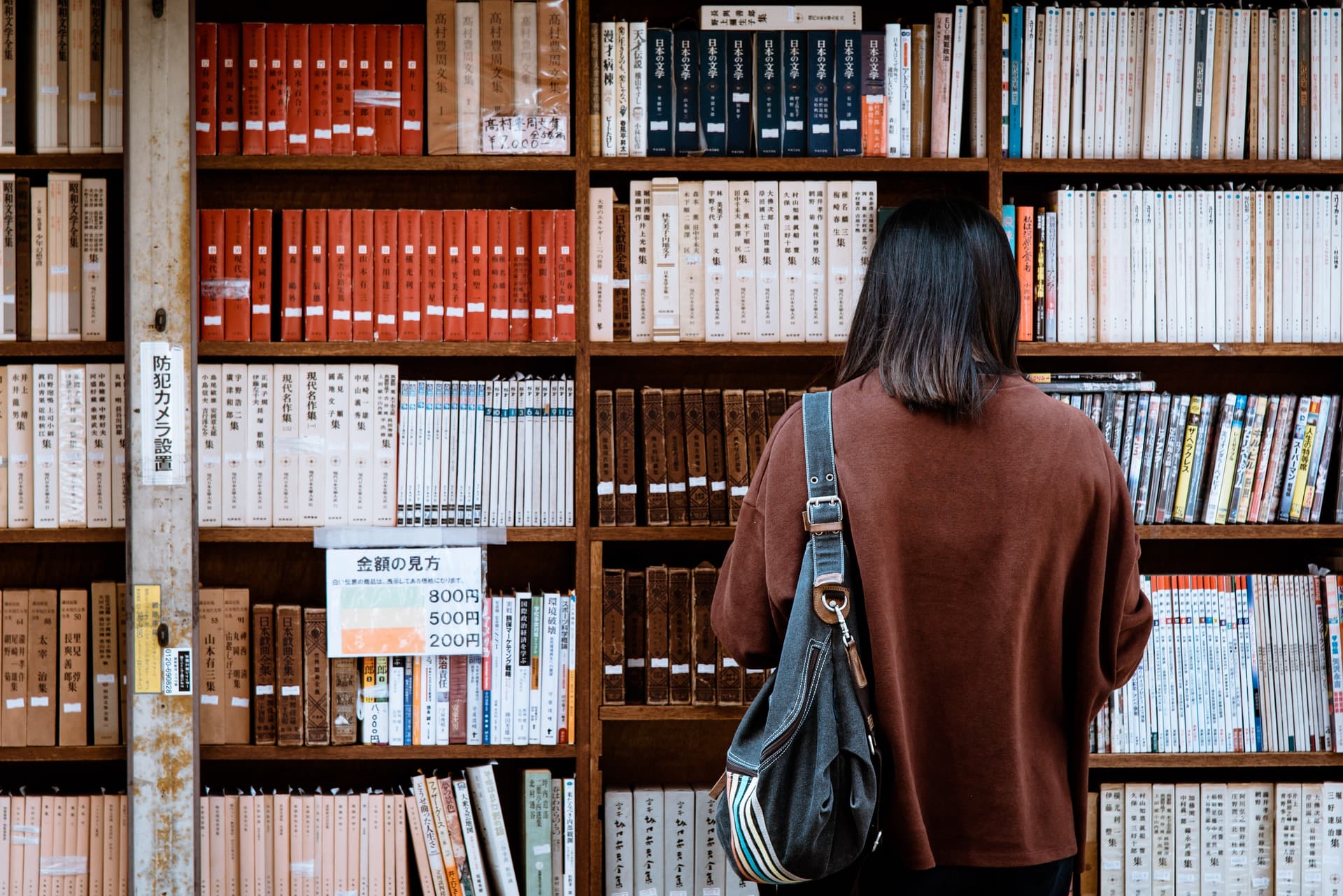 Frau steht vor Bücherregal