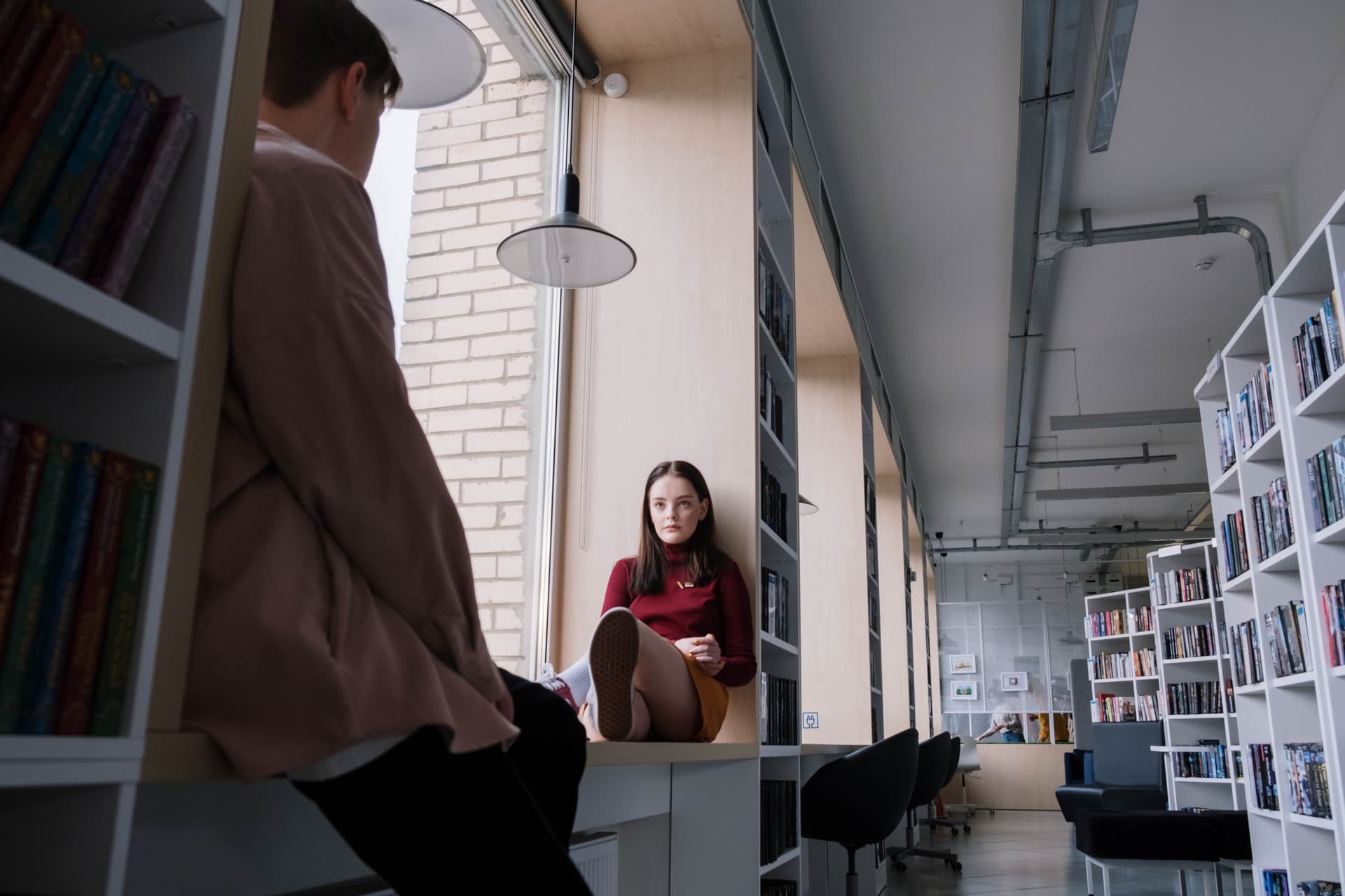 Junge Frau sitzt auf einer Fensterbank