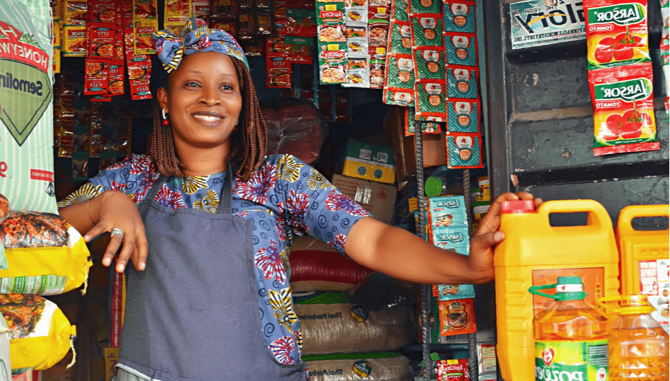 Cliente d'Advans au Nigéria devant son stand d'épicerie au marché