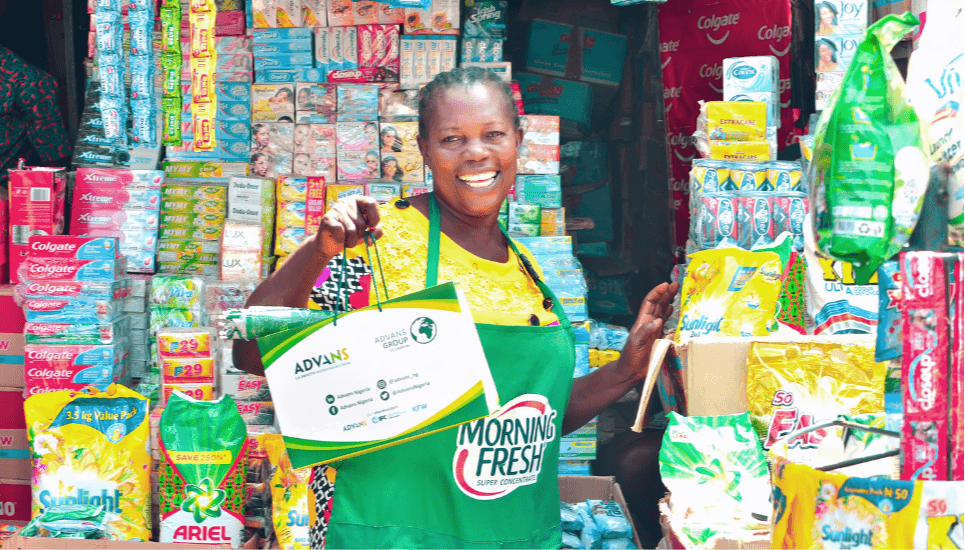 Cliente d'Advans au Nigéria, devant son stand de produits d'hygiène au marché
