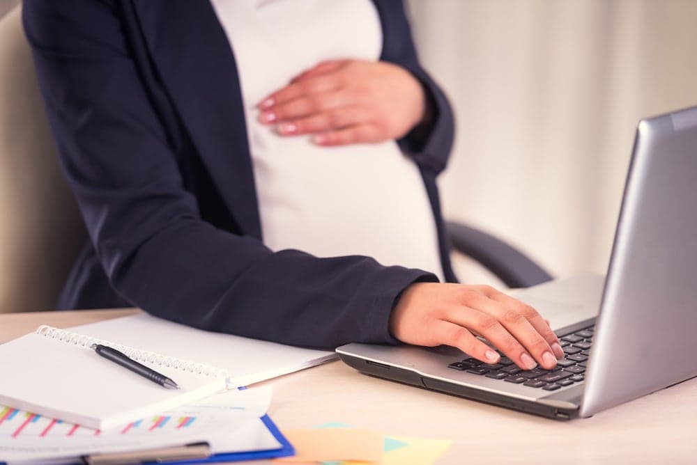 Femme enceinte derrière son bureau de travail