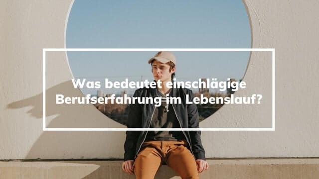 Jonge man zit in de zon op een muurtje en kijkt voor zich uit