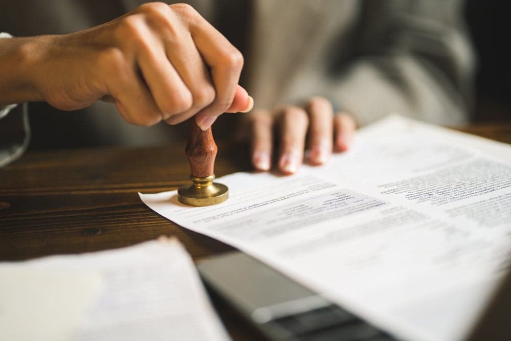 Notaire tamponne un document