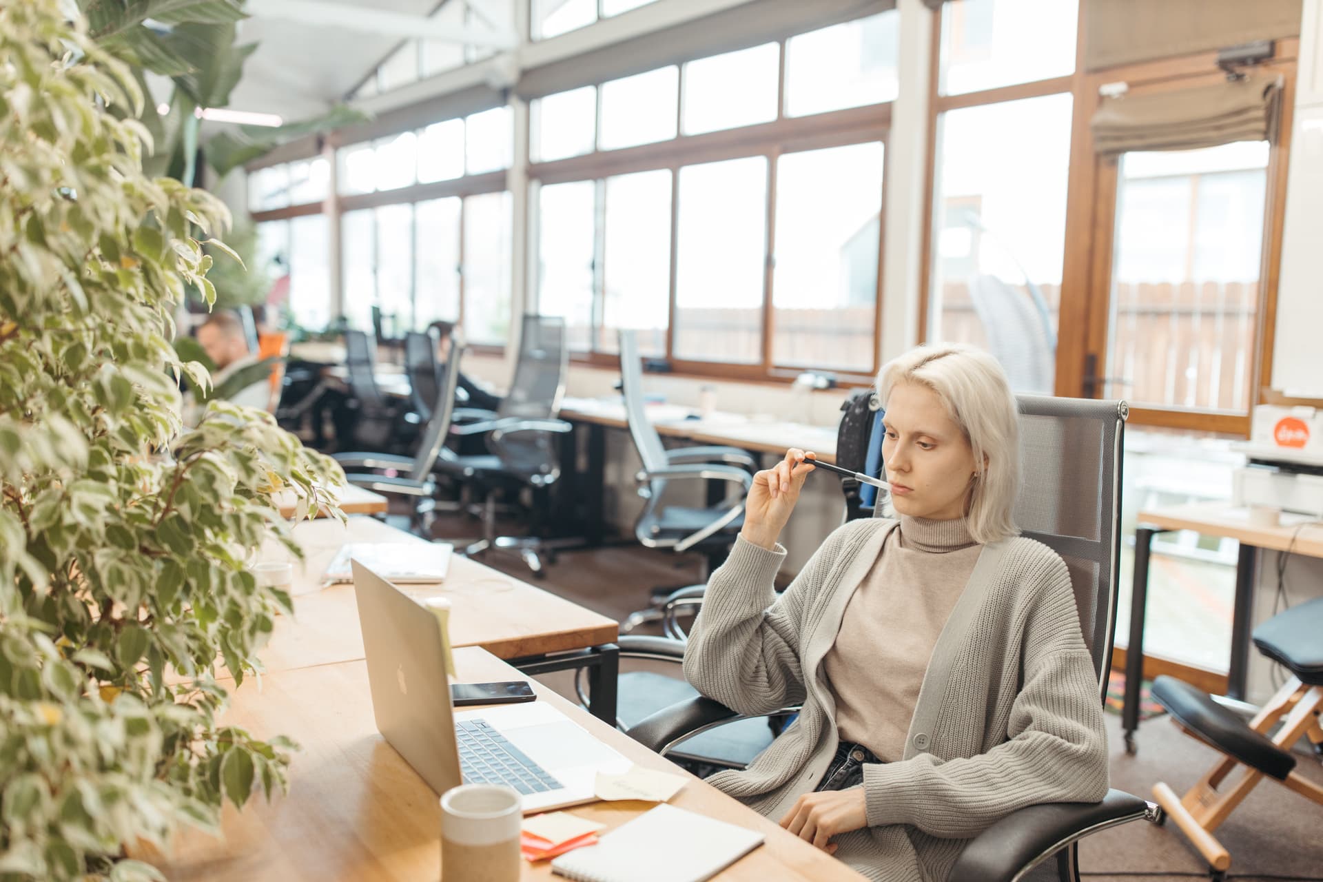 Une femme pensive devant un ordinateur