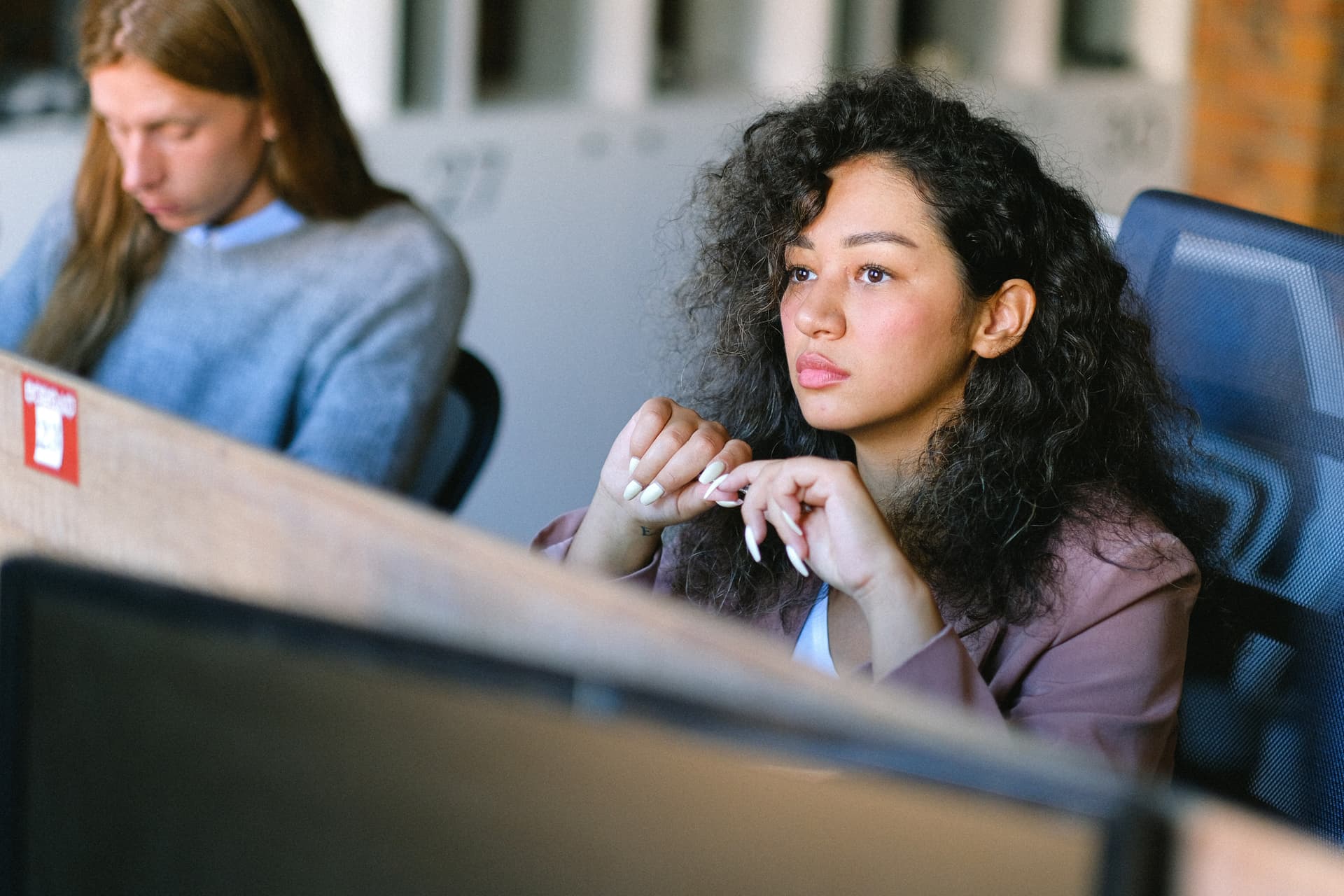 Une femme en train de réfléchir dans un open space