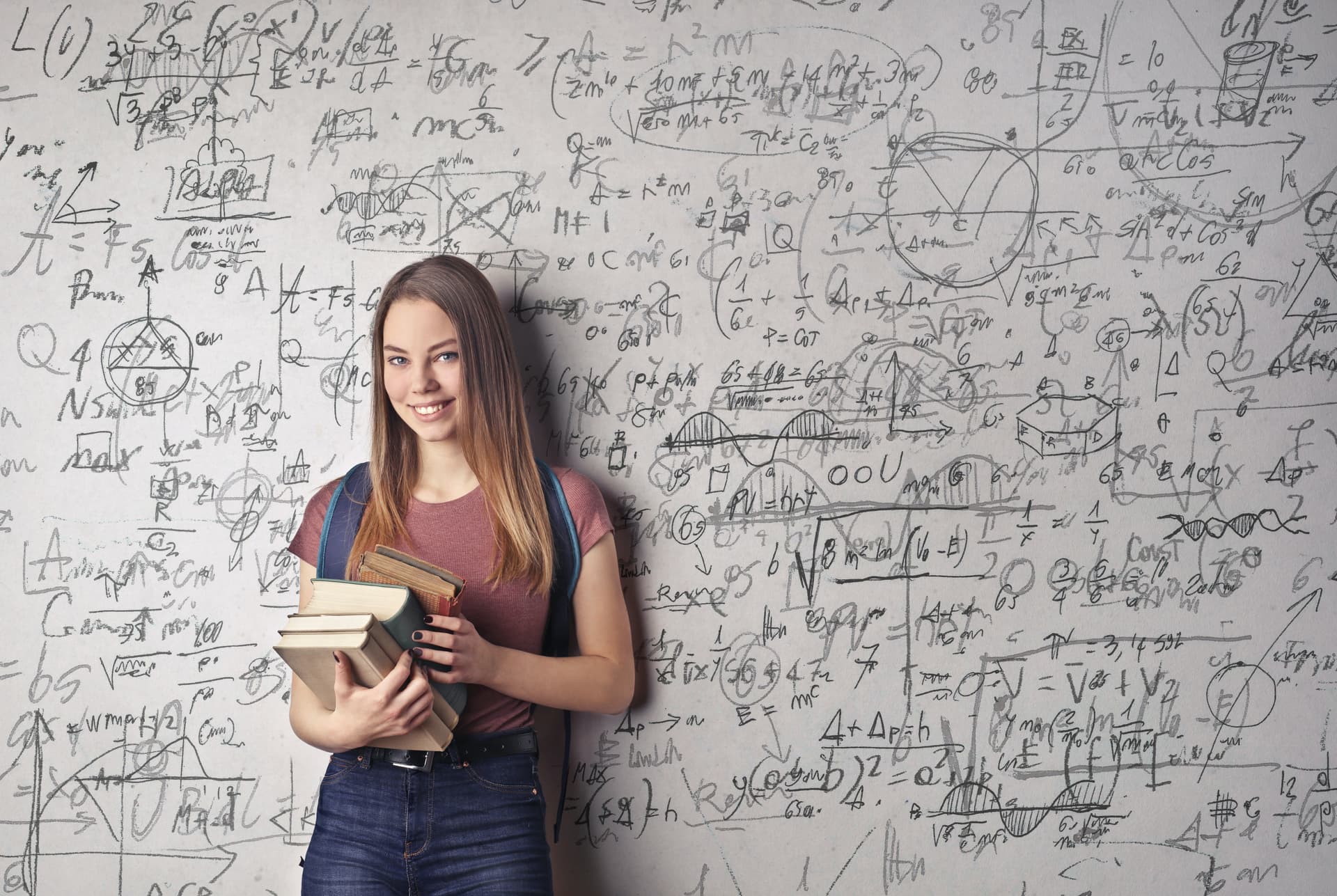 Frau steht vor Tafel mit mathematischen Formeln
