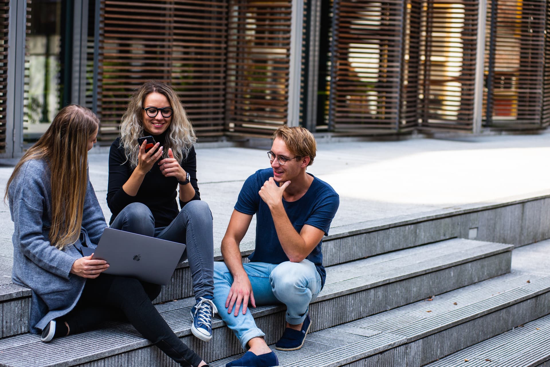 Junge Studierende sitzen auf einer Treppe