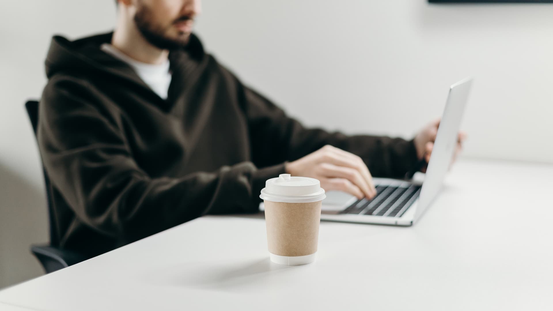 Mann sitzt vor Laptop