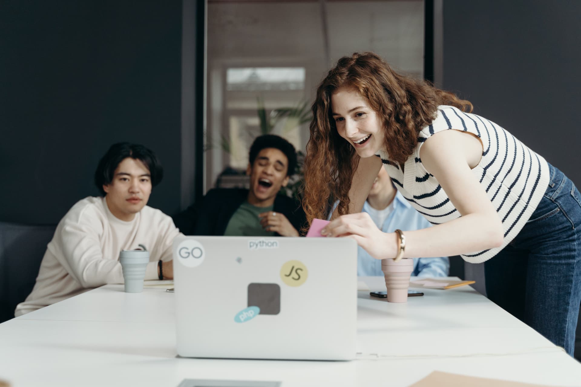 Ein junges Team sitzt um einen Laptop
