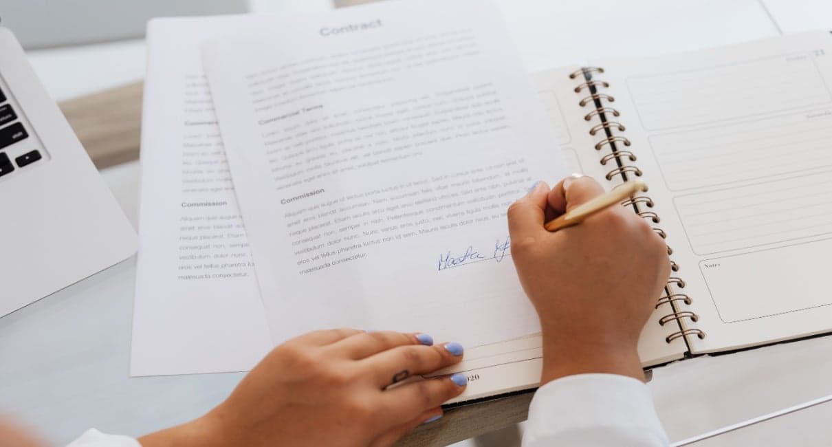 A picture of a person signing a contract